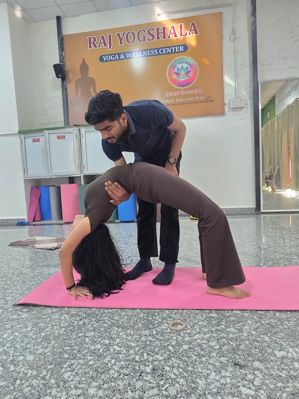 Teacher assisting a yoga backbend at Raj Yogashala